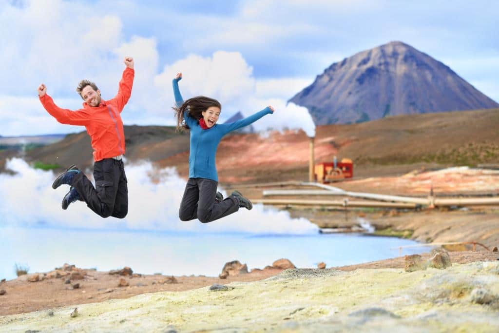 Iceland travel people jumping of joy in nature