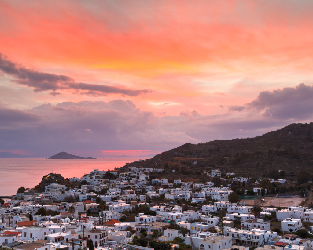 Vue panoramique de l'île de Patmos. Coucher de soleil, ciel rosé/orangé.