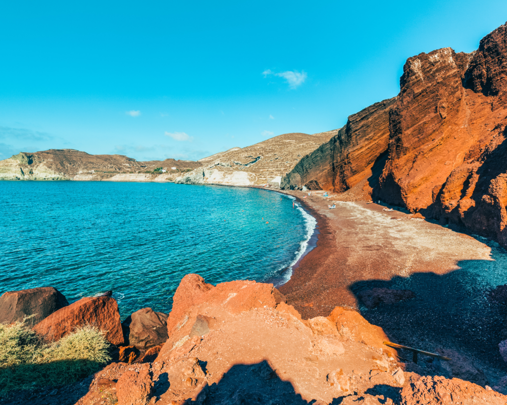 Plage Rouge à Santorin, sable foncé, mer bleu.